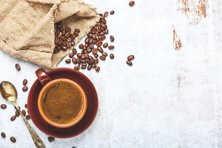 Cup of coffee with beans on rustic wooden backgroundの写真素材