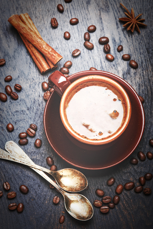 Cup of coffee with beans on rustic wooden backgroundの写真素材