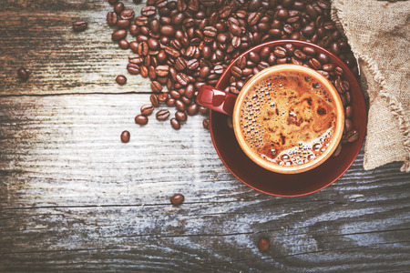 Coffee cup and coffee beans on tableの写真素材