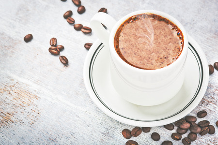 Coffee cup and coffee beans on tableの写真素材