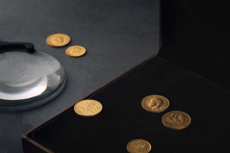 Numismatics. Old collectible coins made of silver, gold and copper on a wooden table.の写真素材
