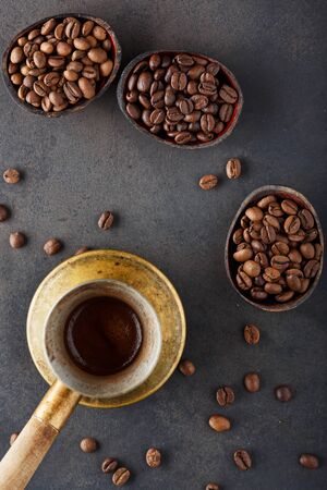 Coffee beans of different varieties and different roasts in three wooden bowls and freshly prepared coffee in cezve. Top viewの写真素材