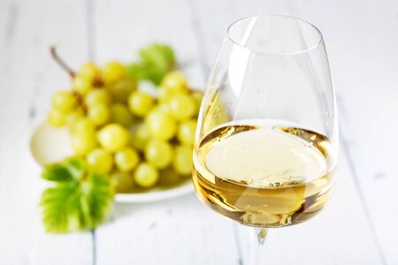 Glass of white wine on vintage wooden table. Light backgroundの写真素材