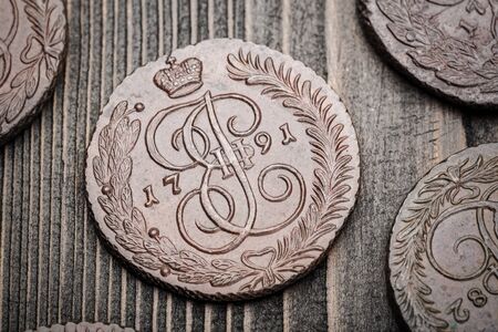 Numismatics. Old collectible coins made of copper on a old wooden table. Top view.の写真素材