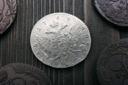 Numismatics. Old collectible coins made of silver and copper on a old wooden table. Top view.の写真素材