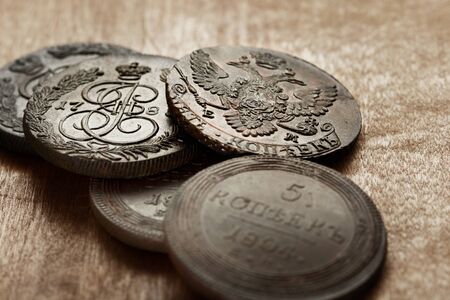 Numismatics. Old collectible coins made of copper on a old wooden table. background.の写真素材