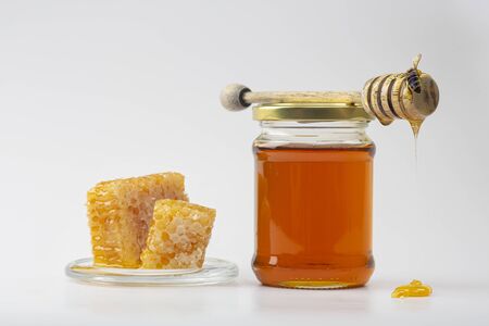 Honey background. Sweet honey in the comb. Fresh honey in a glass jar, honeycombs, a spoon for honey...
