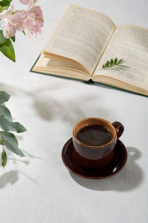 Fresh aromatic coffee in a cup on a white table. Light background.