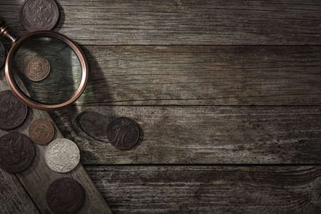 Numismatics. Old collectible coins on a wooden table. Top view. Copy space of your text.の写真素材
