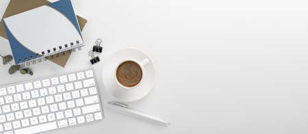 Top view office table desk. Workspace with blank, office supplies, pencil, green leaf, and coffee...