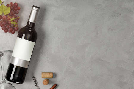 Bottle of red wine with label. Glass of wine and grape. Wine bottle mockup. Top view.