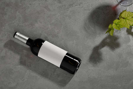 Bottle of red wine with label. Glass of wine and grape. Wine bottle mockup. Top view.の写真素材