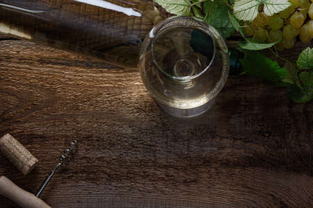 Glass of white wine on vintage wooden table. Top view.