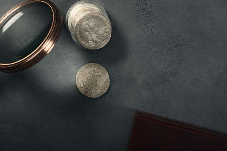 Numismatics. Old collectible coins made of silver on a wooden table. Top view.の写真素材