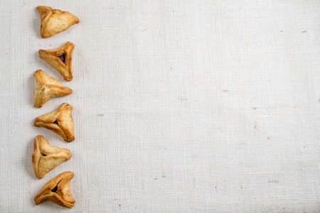 Jewish holiday of Purim. Hamantaschen cookies on canvas background with free space for textの写真素材