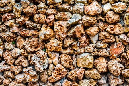 Fragment of stone wall with a porous surface, texture of masonry