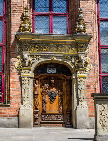 Old vintage wooden door decorated with sculptures and with door knocker in the form of a eagleの写真素材