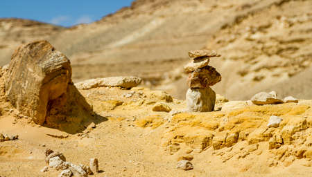 Desert landscape, pyramid of rough stones on foreground in Negev desert, Israel