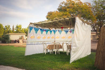 Fabric sukkah decorated with printed pattern and hebrew text of blessing: Grant peace everywhere goodness and blessing, Grace, lovingkindness and mercy to us and unto all Israel, Your people. Toned imageの写真素材