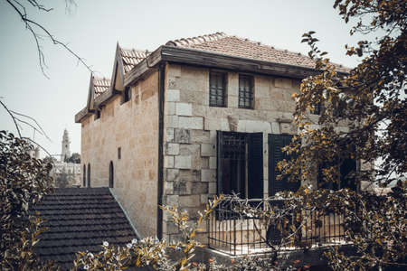 The stone house, built of white stone, tiled roof and windows with shutters, the historic neighborhood Yemin Moshe in Jerusalem, Israel. Toned imageの写真素材