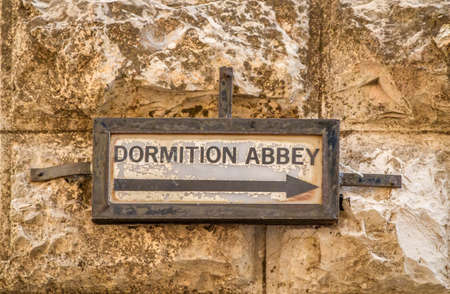 Old street sign on stone wall, The Dormition Abbey, catholic church in Jerusalem, Israel.の写真素材