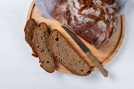 Freshly baked rye bread sliced in the traditional way. Single object on a wooden background. Top view, copy space.の写真素材