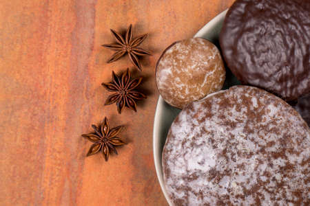 Typical German gingerbread cookies and anise stars on an orange background. Traditional Christmas treat. Front view, copy space.の写真素材