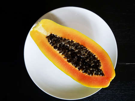 Sliced ripe papaya on black backgroundの写真素材