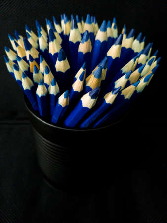 Blue pencils on black background
