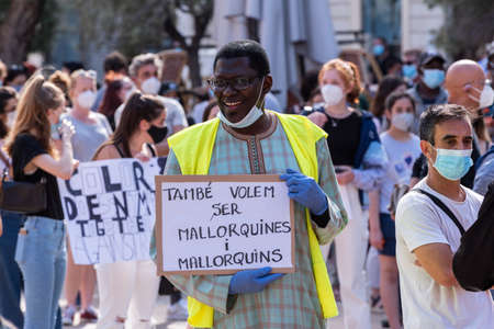 Palma de Mallorca, Spain - June 07 2020: Man surrounded by crowd holding a placard with messageのeditorial素材
