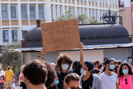 Palma de Mallorca, Spain - June 07 2020: Young boy with mask surrounded by crowd holding a banner in a peaceful protest against racism.のeditorial素材