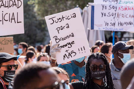 Palma de Mallorca, Spain - June 07 2020: woman stands out from the crowd with face mask with message "I can't breathe" and banner supporting Breonna, George and others affected by police brutalityのeditorial素材
