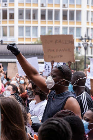 Palma de Mallorca, Spain - June 07 2020: Man with mask surrounded by crowd raising the fist in a peaceful protest against racism and recent US police brutalityのeditorial素材