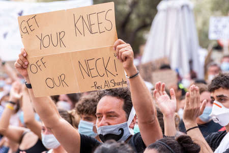 Palma de Mallorca, Spain - June 07 2020: Man surrounded by crowd holding a placard in a peaceful protest against racism and recent US police brutalityのeditorial素材