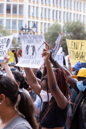 Palma de Mallorca, Spain - June 07 2020: Woman surrounded by crowd holding a banner in a peaceful protest against racism and recent US police brutalityのeditorial素材
