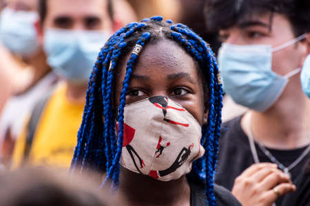 Palma de Mallorca, Spain - June 07 2020: Young girl with face mask standing out from the crowd for her blue hair in a pacifist protest against racismのeditorial素材