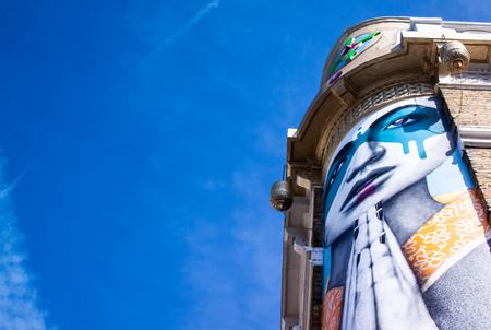 A graffiti of a woman with united hands along Portobello road in Londonのeditorial素材
