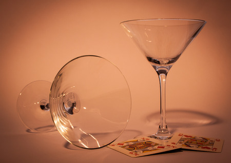 two glasses with violet background one standing and one downの写真素材