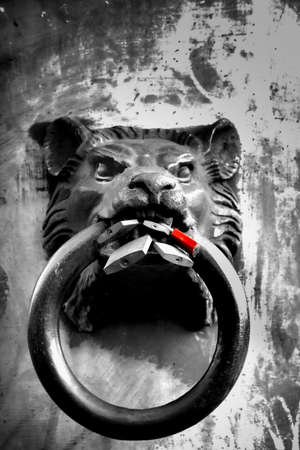 An iron lion head with a big ring in the mouth, black and whiteの写真素材