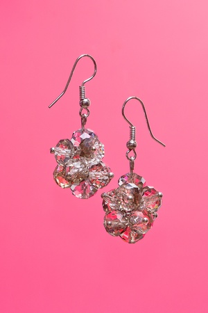 Shining elegant modern earrings with zircons on pink backgroundの写真素材