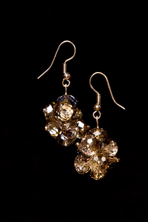 Shining elegant modern earrings with zircons isolated on blackの写真素材