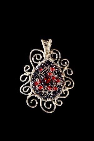Unique handmade wire-work pendant with red and silver beadsの写真素材
