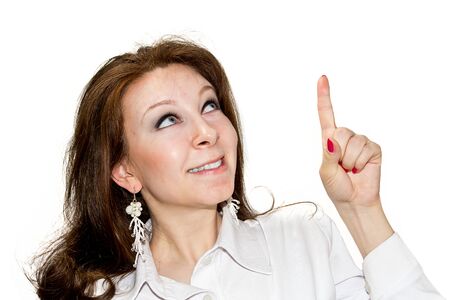 Young women points upward and draws attention isolated on whiteの写真素材
