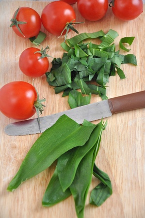 Fresh wild garlic Allium ursinum with tomatoesの写真素材