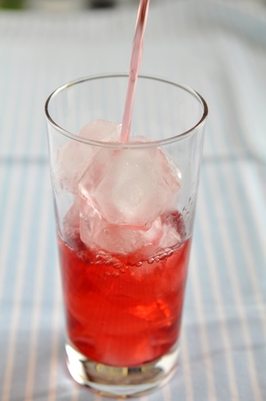 Pouring Red Drink into drinking glassの写真素材