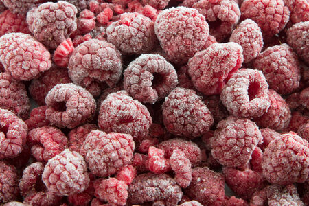 Fresh Ripe Raspberries frozen on a table
