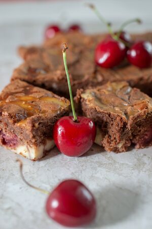 Chocolate brownie pieces decorated with cherryの写真素材