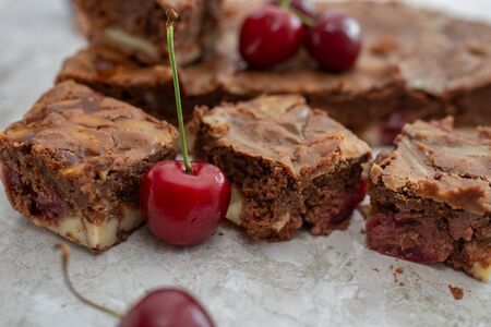 Chocolate brownie pieces decorated with cherryの写真素材
