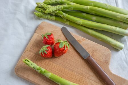 Green fresh asparagus with a bunch of healthy strawberriesの写真素材
