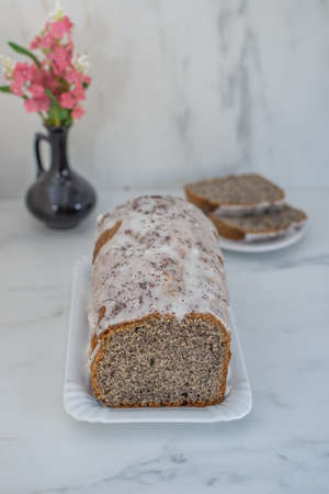 sweet home made poppy seed pie with lemon glaze on a table